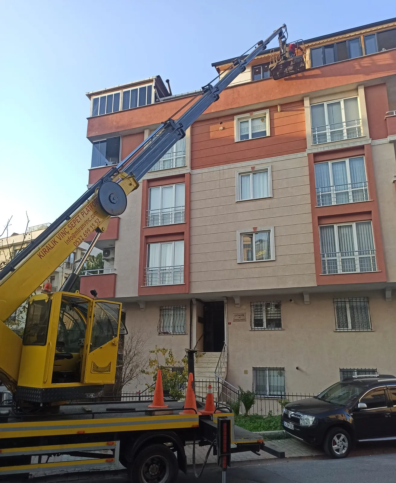 Dış cephe çalışması için bina önünde konumlanmış Miran Vinç sepetli platformu