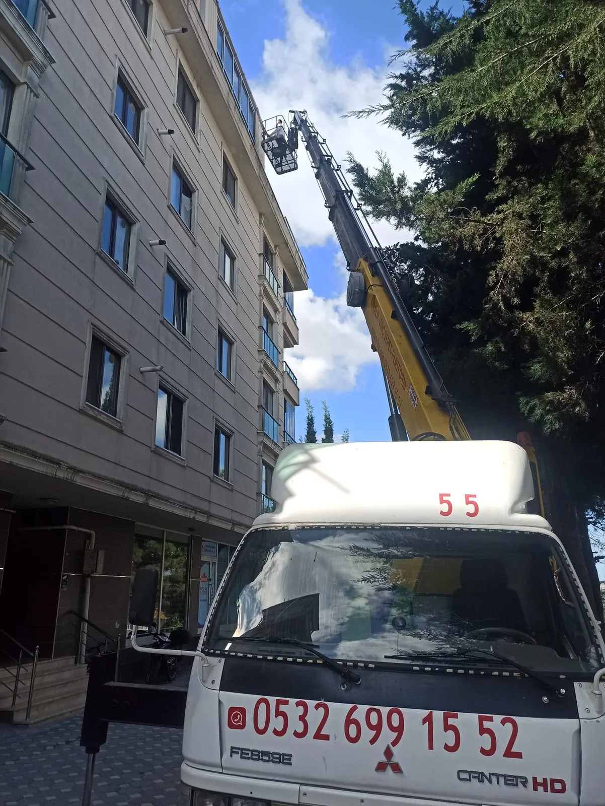 Dış cephe mantolama ve dış cephe çalışması için bina önünde konumlanmış Miran Vinç sepetli platformu